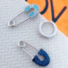 huggie hoop with dangling pin shape.