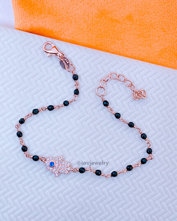 rosegold hamsa shape bracelet with black faceted onyx beads.