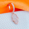 rosegold huggie hoop earring with dangling hamsa shape earring.