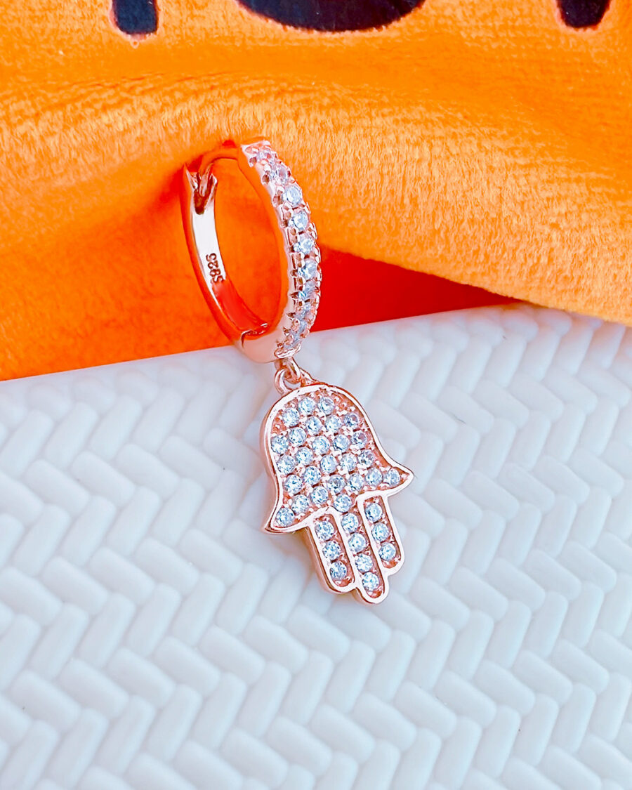 rosegold huggie hoop earring with dangling hamsa shape earring.