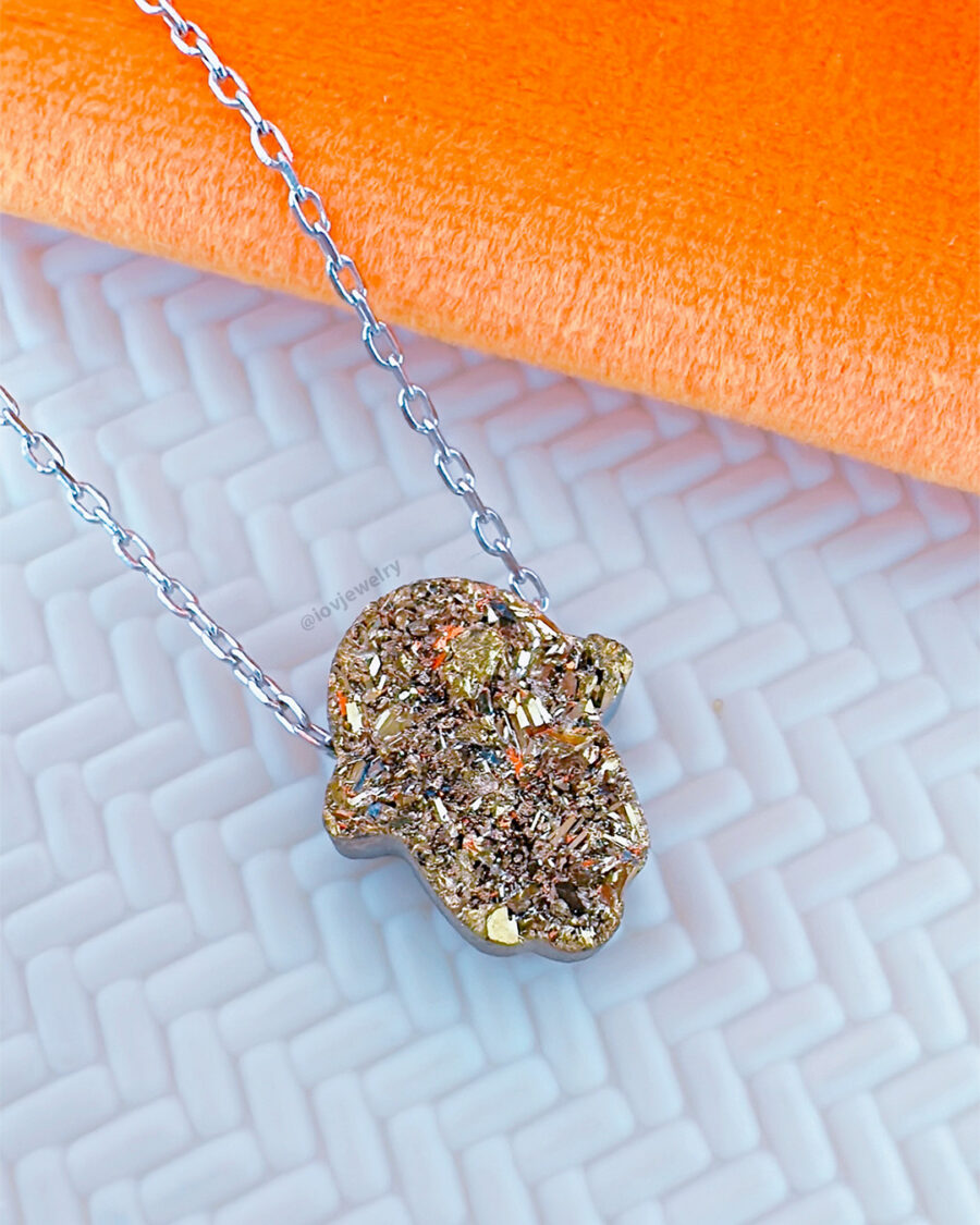 Hamsa shape movable stone multi faceted golden color necklace.