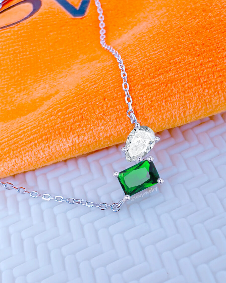 emerald color rectangular and white pear shape toi et moi model necklace.
