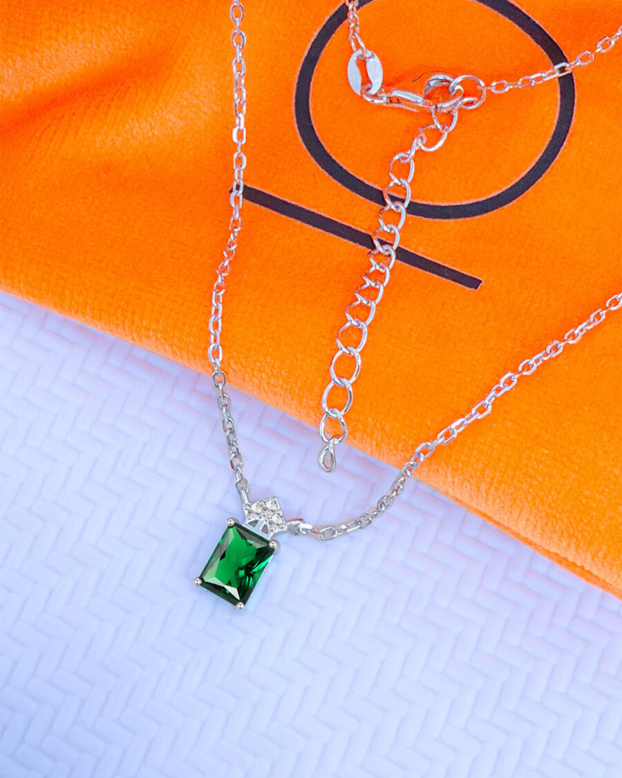 emerlad cut green CZ stone with three white stones neckace.