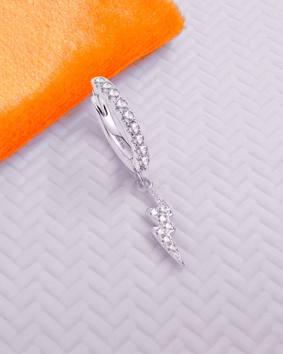 CZ huggie hoop earring with dangling bolt sign.